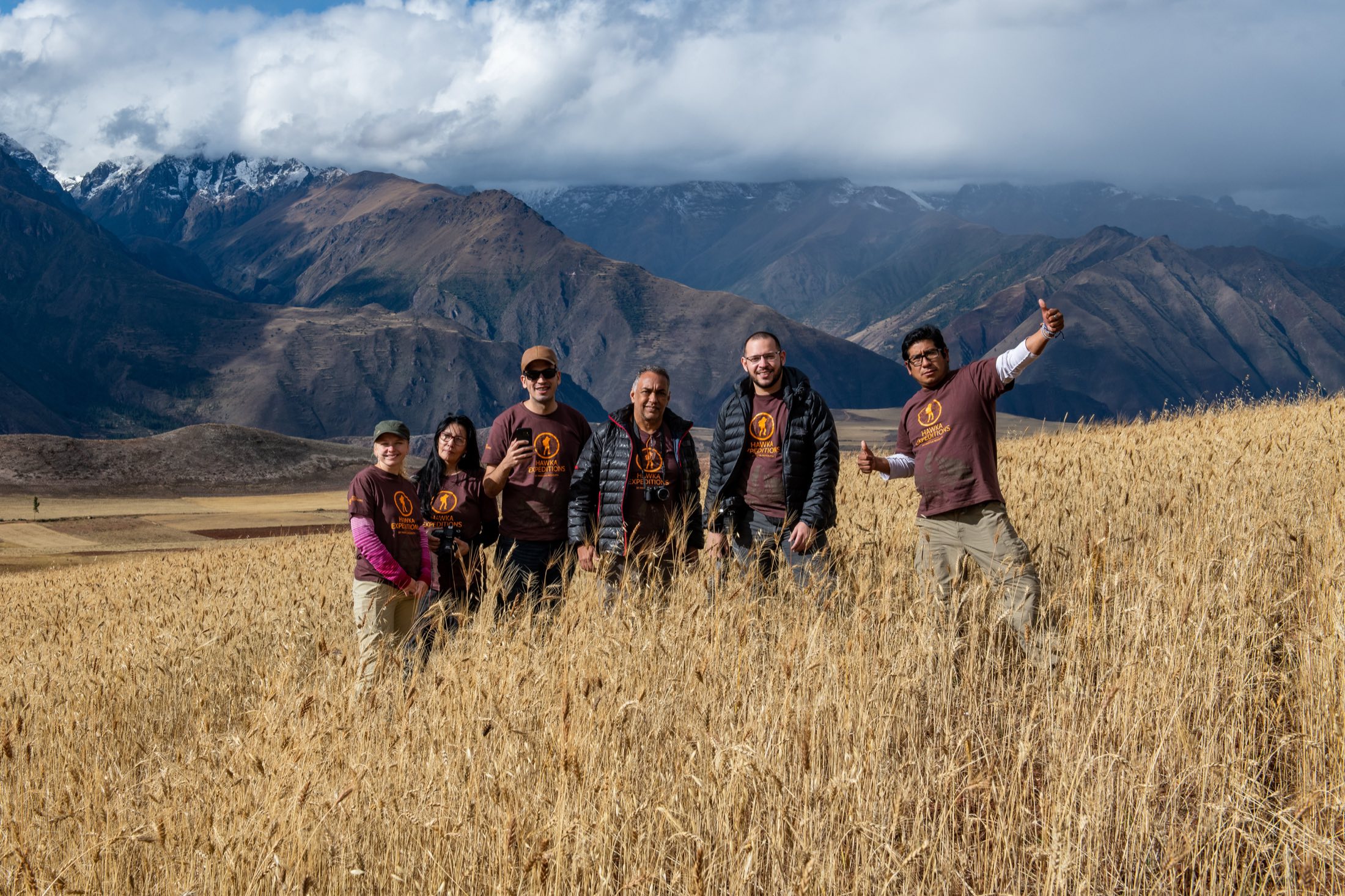 Grupo da Hawka Expeditions em um campo de trigo nos Andes peruanos