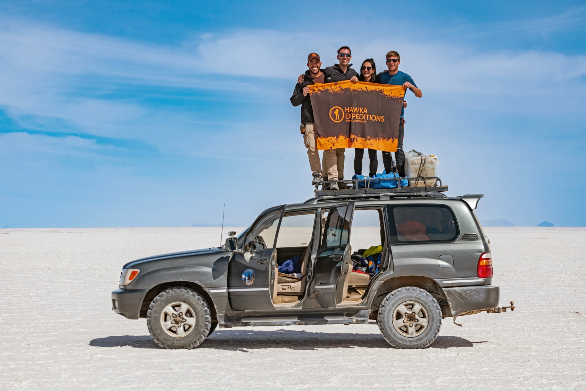 Grupo da Hawka sobre o teto do veículo no salar